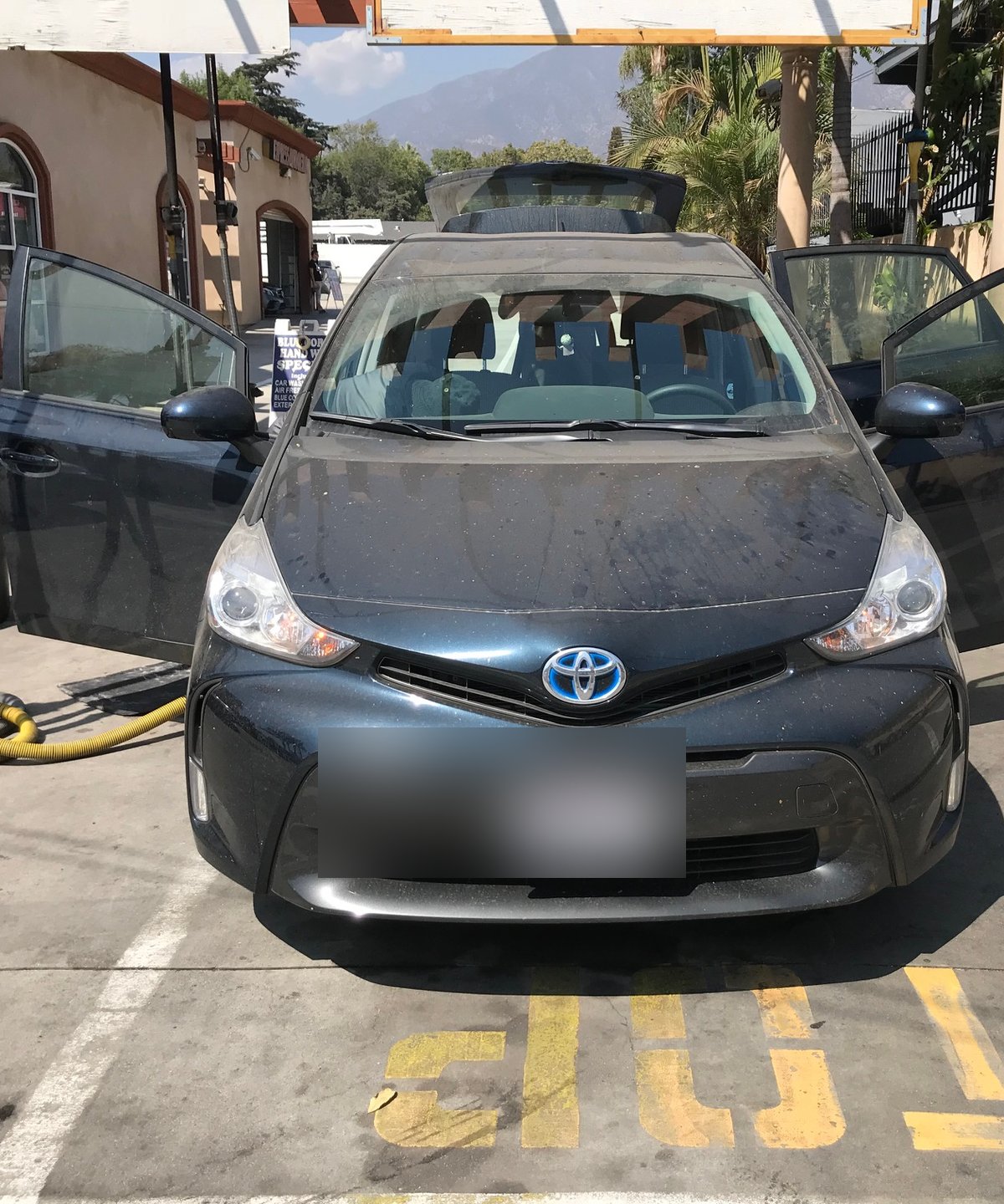 Vehicle being serviced in the bay at Fair Oaks Car Wash with the San Gabriel mountains in the background